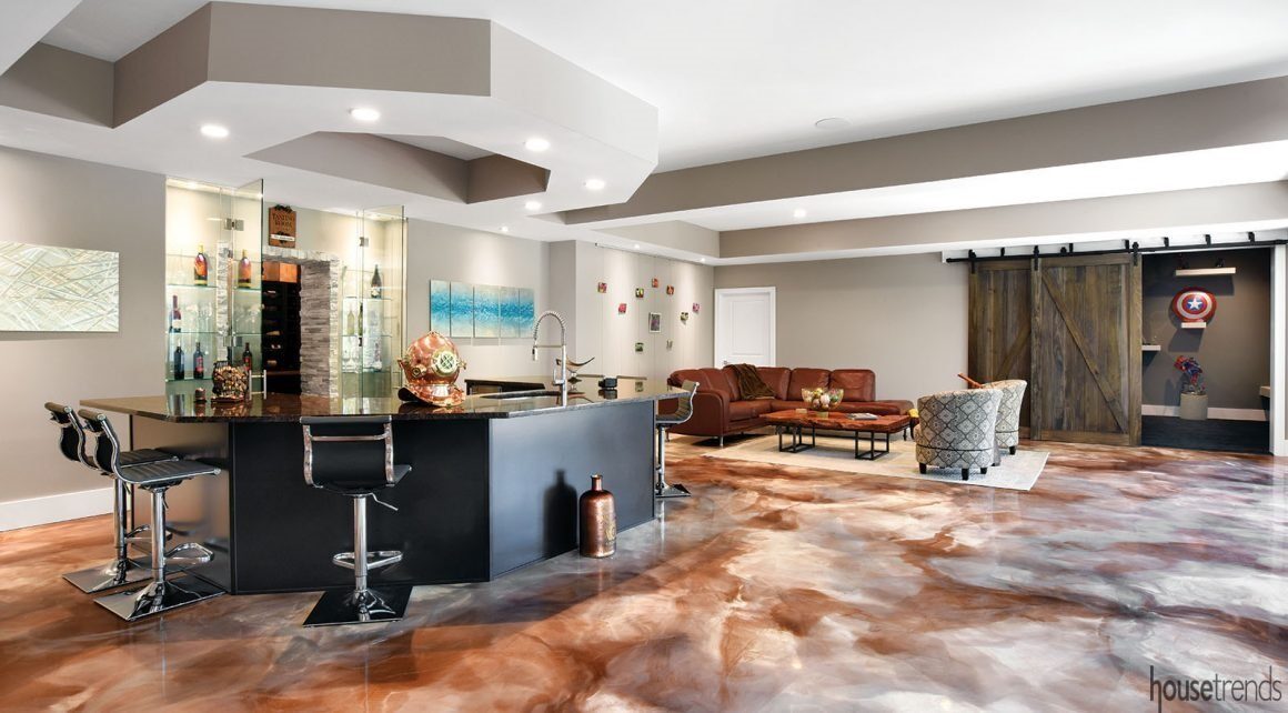 Elegant u-shaped bar with barstools. Wine bottles sit on glass shelves behind it.
